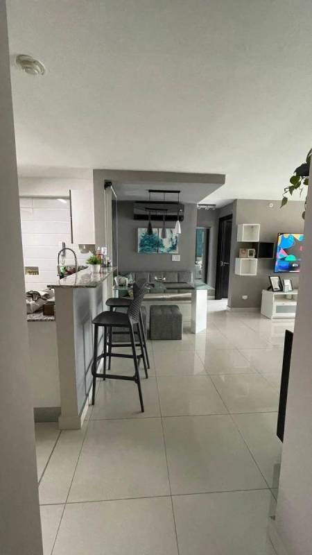 Open dining area next to modern kitchen with breakfast bar at PH Mid Park Panama