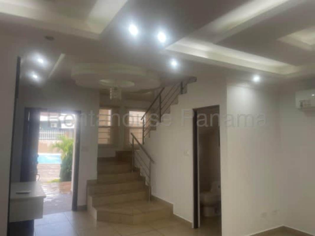 Open concept living with staircase, large windows and pool view in Olympus II Panama