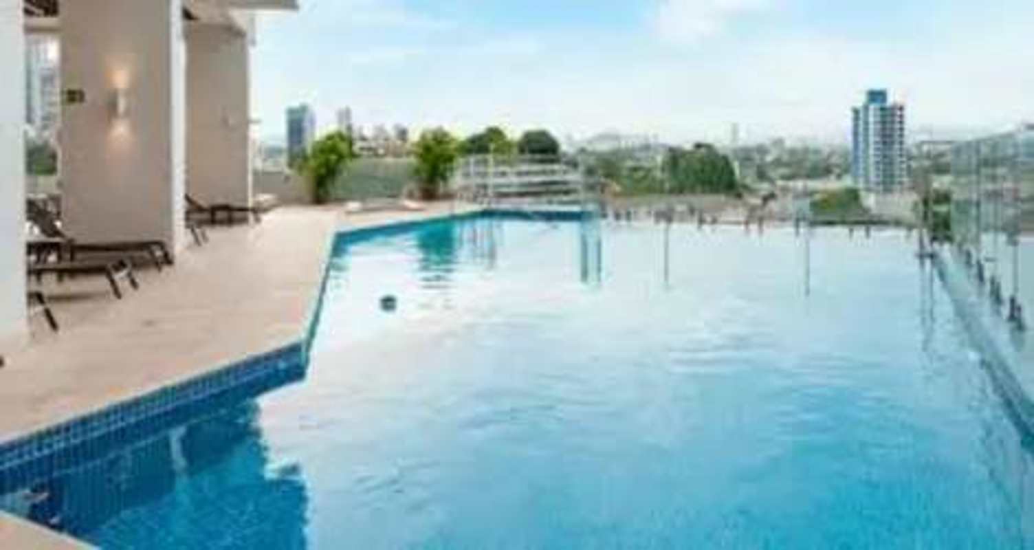 Infinity pool on rooftop with lounge chairs overlooking city skyline in Edison Park Panama City