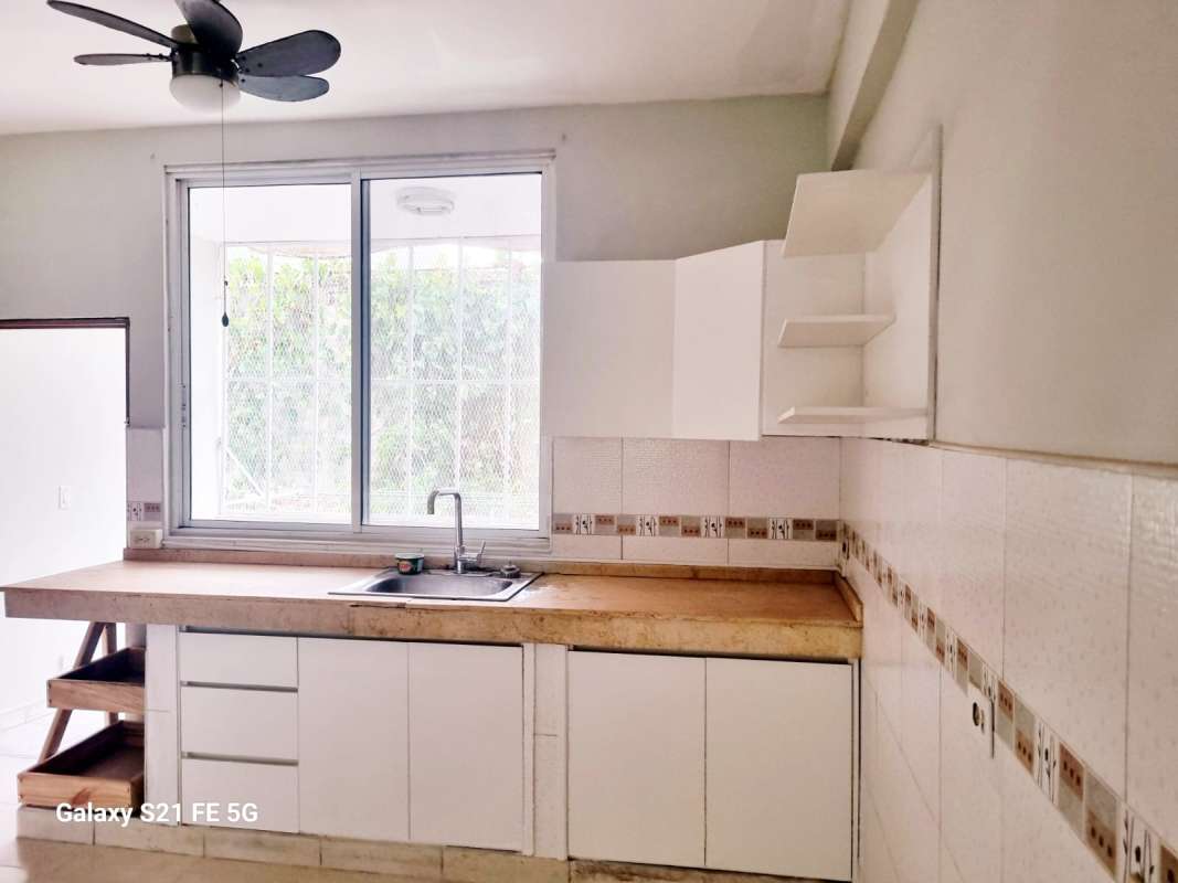 Bright simple kitchen with window, breakfast bar and ceramic counters in San Francisco apartment