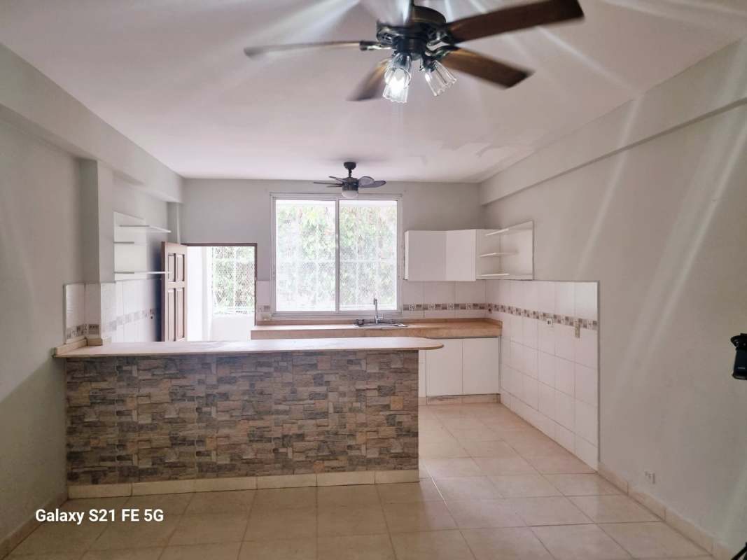 Open kitchen with stone accent breakfast bar and large window in Panama apartment rental