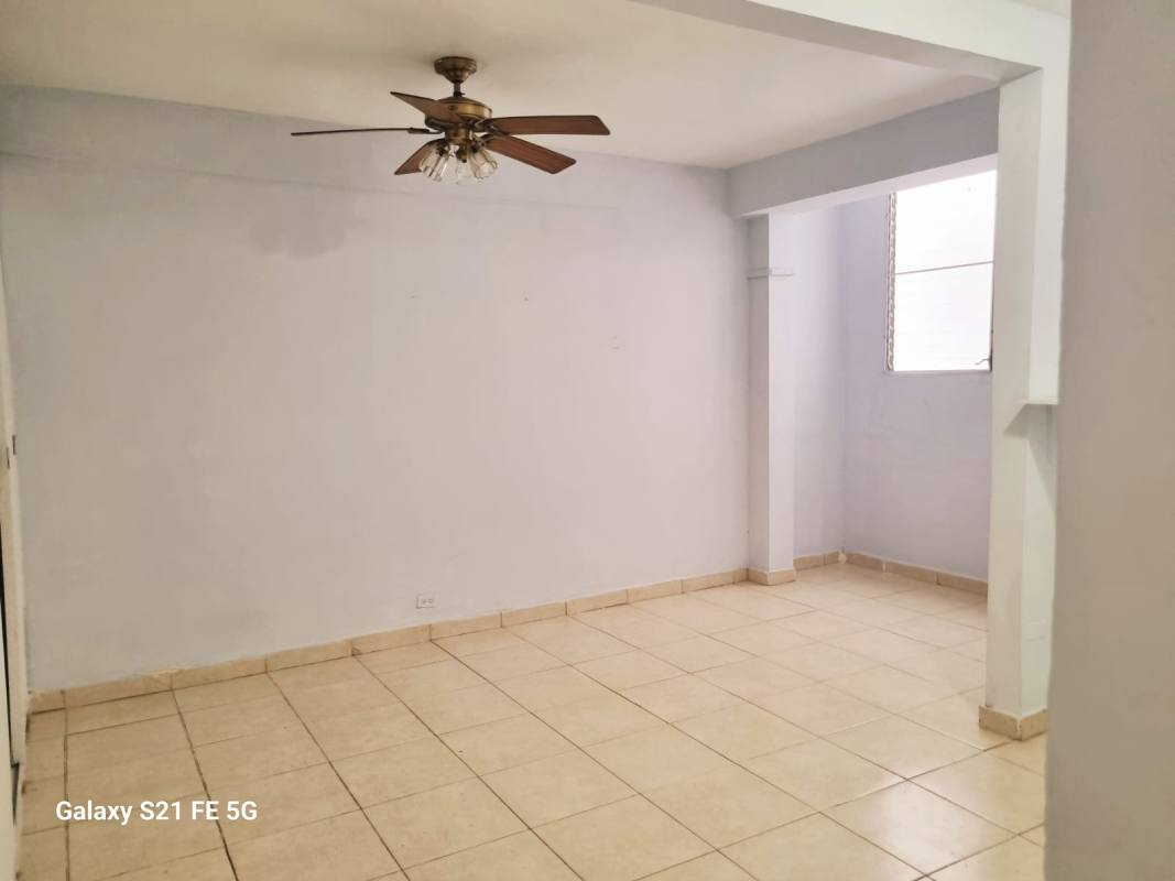 Minimalist living room with tile floors, ceiling fan and large window in Panama apartment