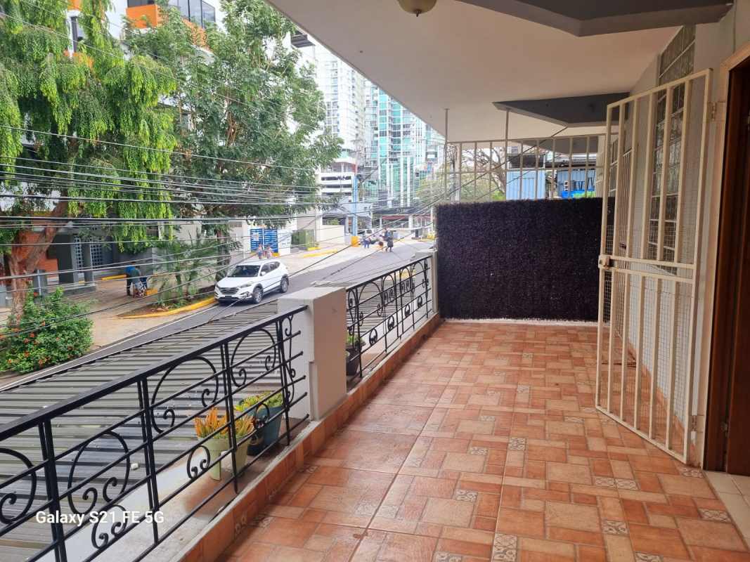 Urban balcony with decorative railing, partial skyline, neighborhood street view in Panama rental