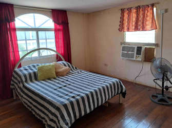 Rustic loft lounge area with wooden floor and large window in Gorgona beach house Panama