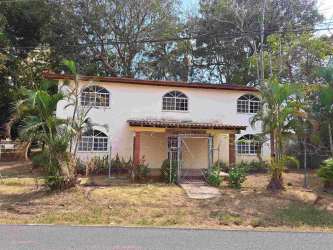 Bright bedroom with arched window, wood floors, AC in Gorgona beach home Panama