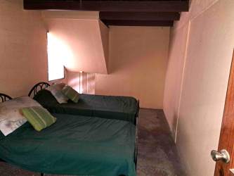 Open living dining area with high ceiling, mezzanine balcony, rustic decor, Playa Malibu Panama