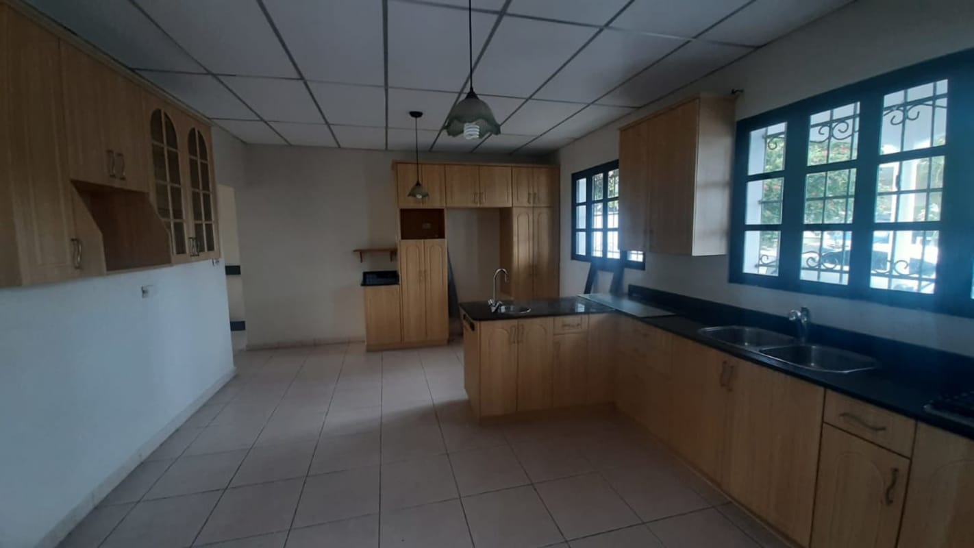 Modern kitchen with light wood cabinetry, granite counters, large windows in Villa Bella Panama