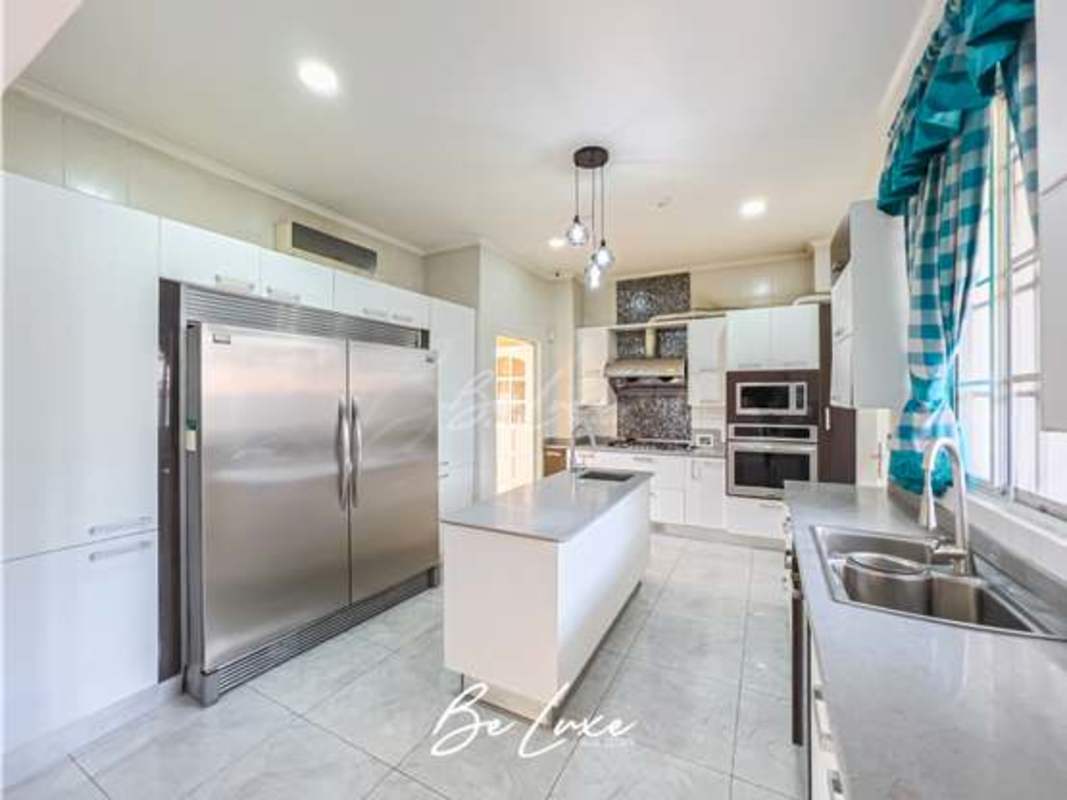 Modern kitchen with stainless steel appliances, large island, double door fridge in luxury home Altos del Golf Panama City