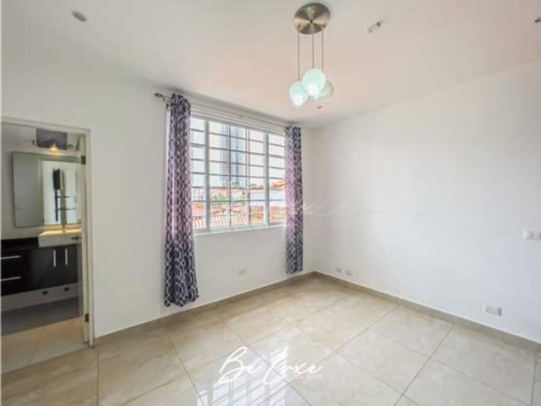 Spacious bedroom with large windows, ensuite bathroom in Altos del Golf Panama luxury home for rent