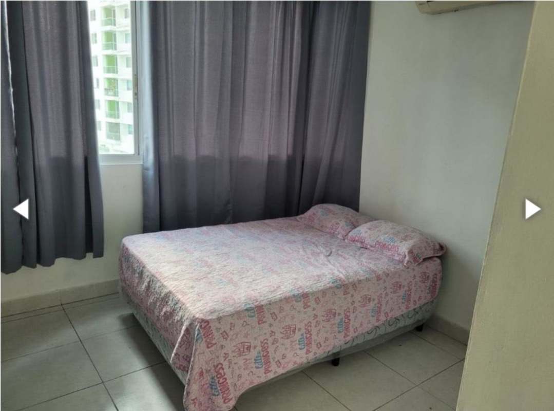 Bedroom with grey curtains, pink bedding, AC and window overlooking city in PH Torre Vivendi Edison Park Panama