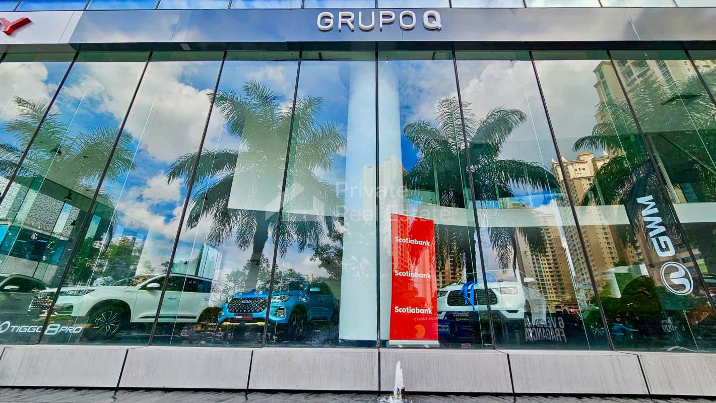 Open workspace on mezzanine floor overlooking showroom with glass railing in Punta Pacífica Panama