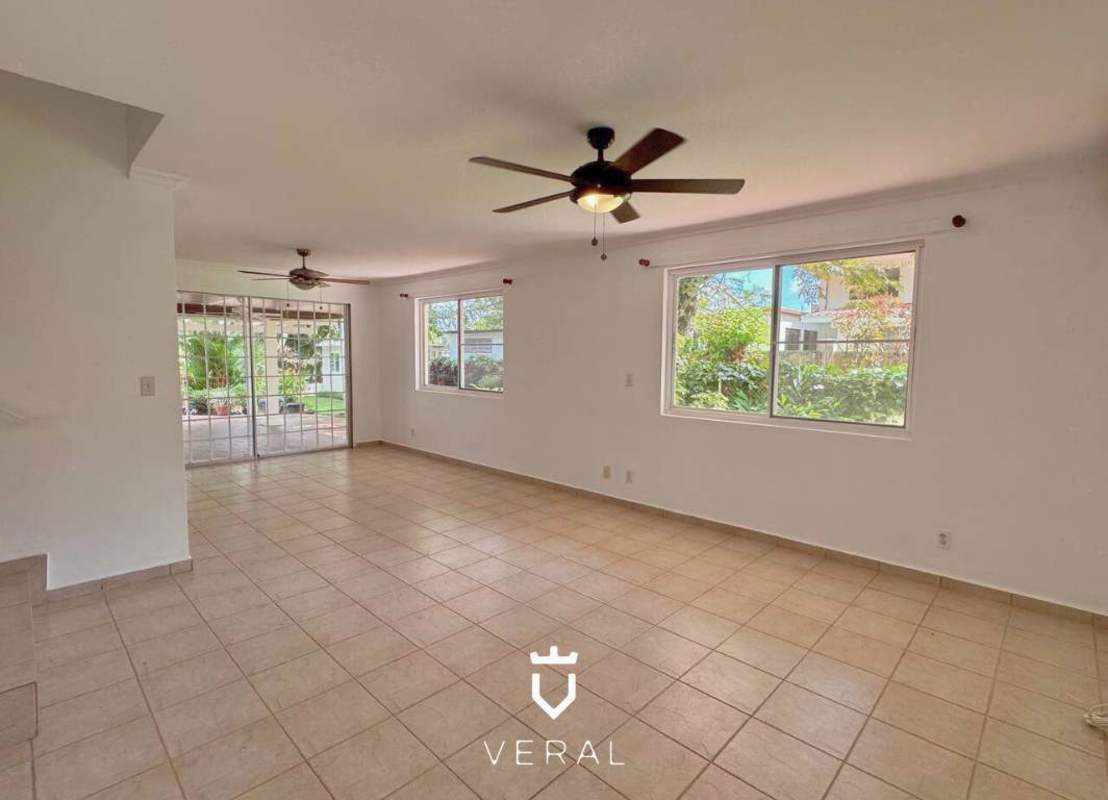 Bright living room with marble floors, large windows, ceiling fan, garden access in Cardenas Village Panama