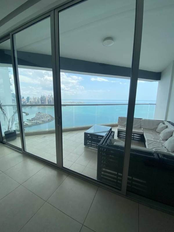 Bright living area with floor-to-ceiling windows showing panoramic ocean views in PH Rivage Panama City