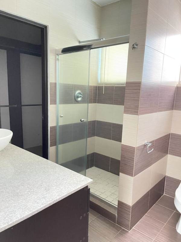 Contemporary bathroom featuring vessel sinks, granite counter, and glass enclosed shower