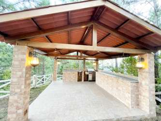 Dining area with big windows and spiral stairs overlooking mountains Coclé