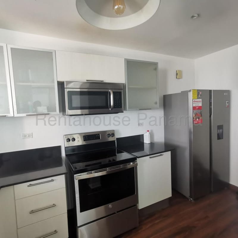 Modern kitchen with white cabinetry, granite counters and stainless appliances at PH Riverside Costa del Este Panama