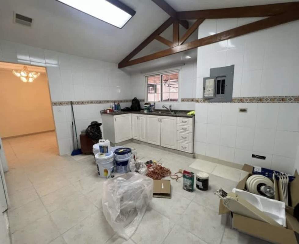 Kitchen with exposed wood beams, granite countertop, and large window rental house Chanis Panama