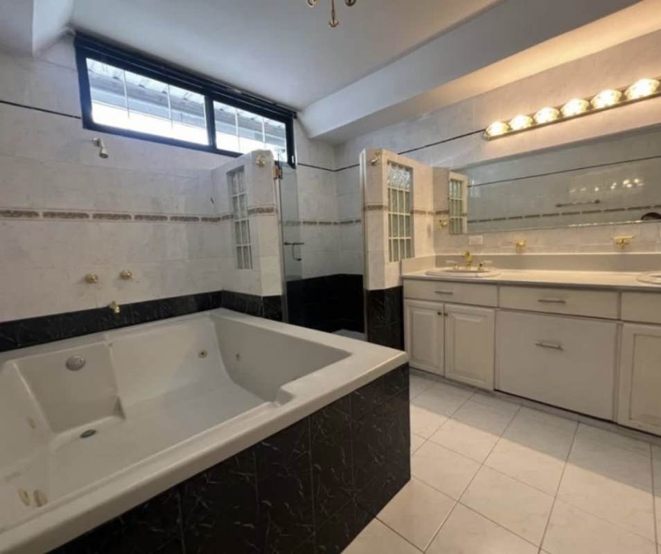 Master bathroom in Chanis house rental featuring jacuzzi tub, walk-in shower, and dual sinks
