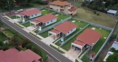 Aerial neighborhood view with single-story houses, red roofs, green lawns in Residencial Costa Verde La Chorrera