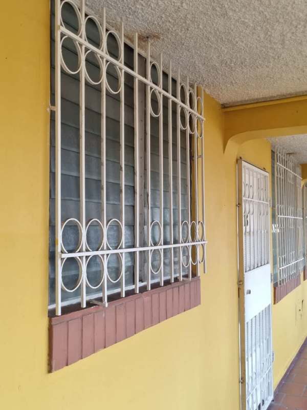 Exterior corridor with metal security door and yellow facade at PH Colonial San Francisco Panama