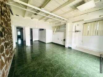 Living room featuring exposed beams, stone wall and tiled floors commercial duplex Doleguita David