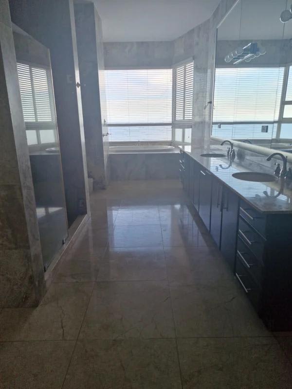 Modern marble bathroom with bathtub and expansive ocean views in Trump Tower Panama City