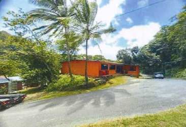 Bright orange tropical rural house surrounded by palm trees and lush forest Santa Fe Veraguas