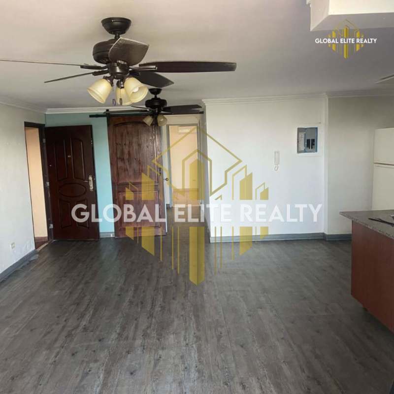 Kitchen with wood cabinetry, granite countertop, and appliances in Carrasquilla apartment