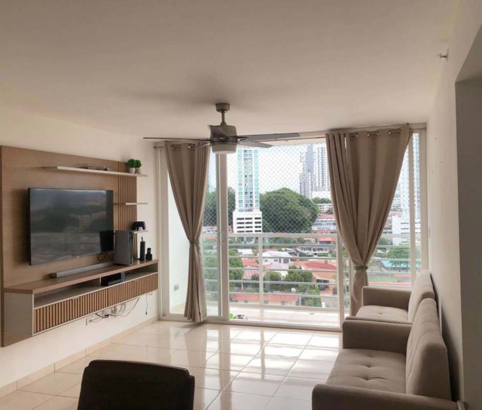 Bright city view living room furnished with sofa, TV unit, access to balcony PH Hato Tower Panama City