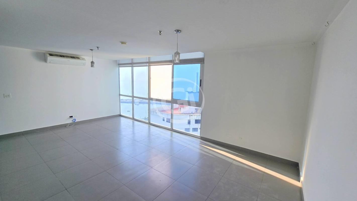 Spacious living and dining room with floor-to-ceiling windows and ocean skyline view in Colores de Bella Vista Panama City