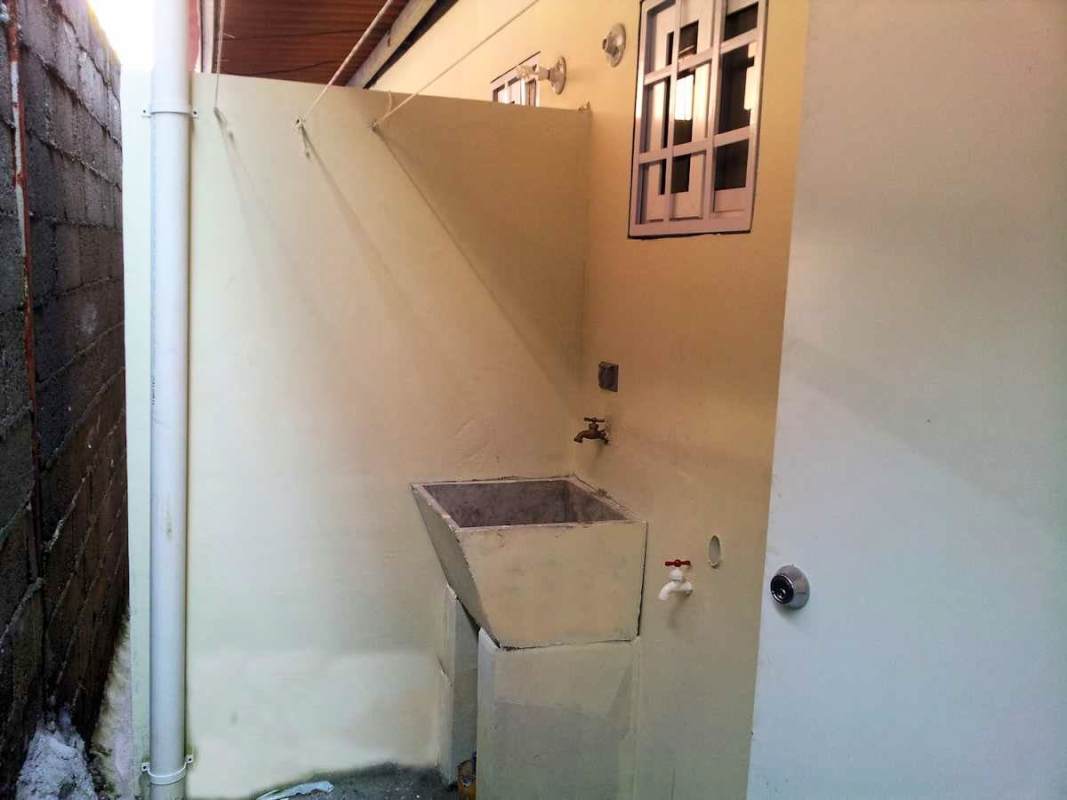 Covered laundry areas behind multi-unit building Villa Lucre Panama