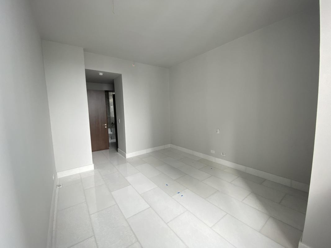 Modern kitchen with central island, quartz countertops and integrated appliances at PH The Towers Paitilla