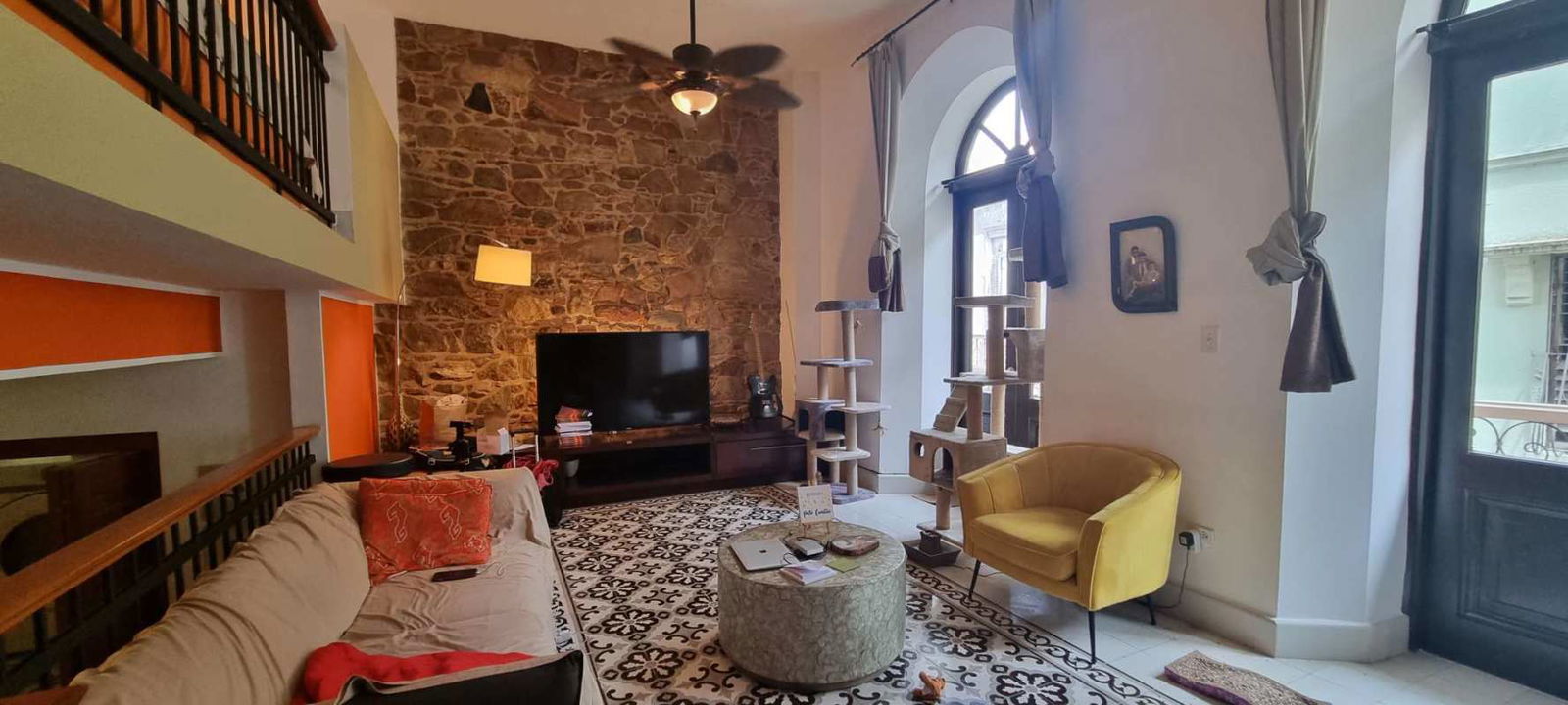 Contemporary kitchen with granite countertops, stainless steel appliances, and stacked laundry in historic loft