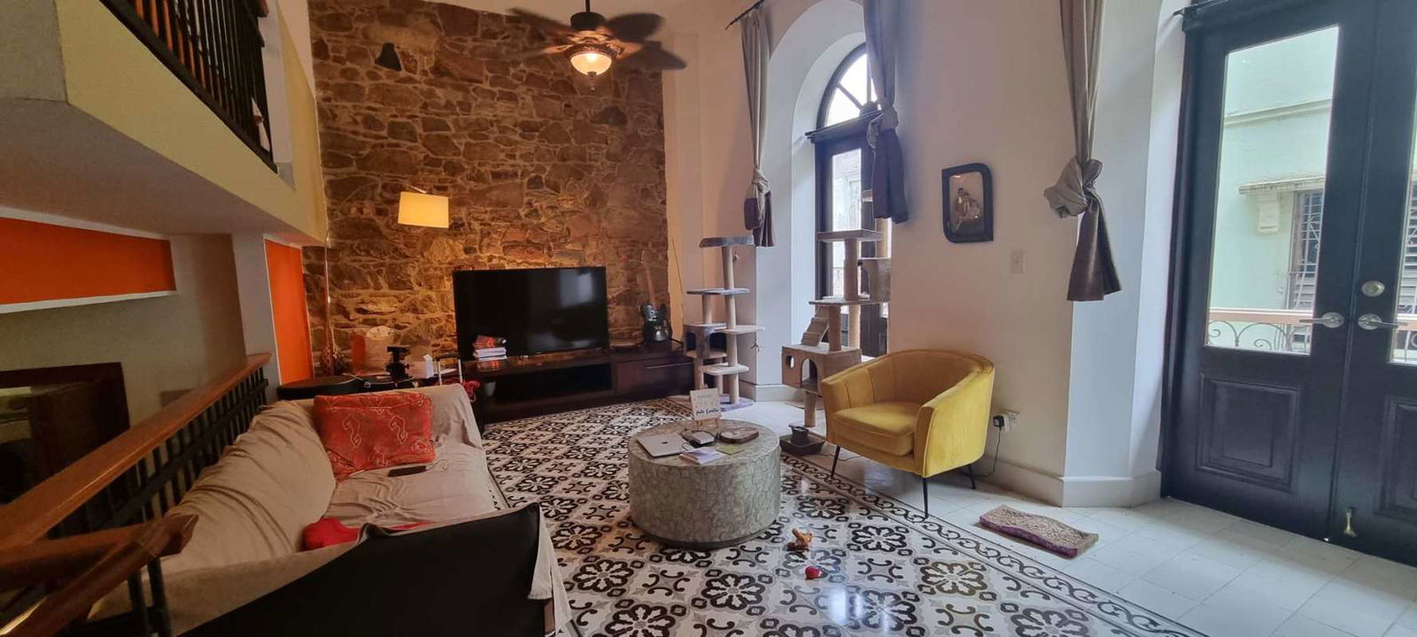 Mezzanine loft bedroom with original stone wall, high ceilings, and bright windows Casco Viejo Panama