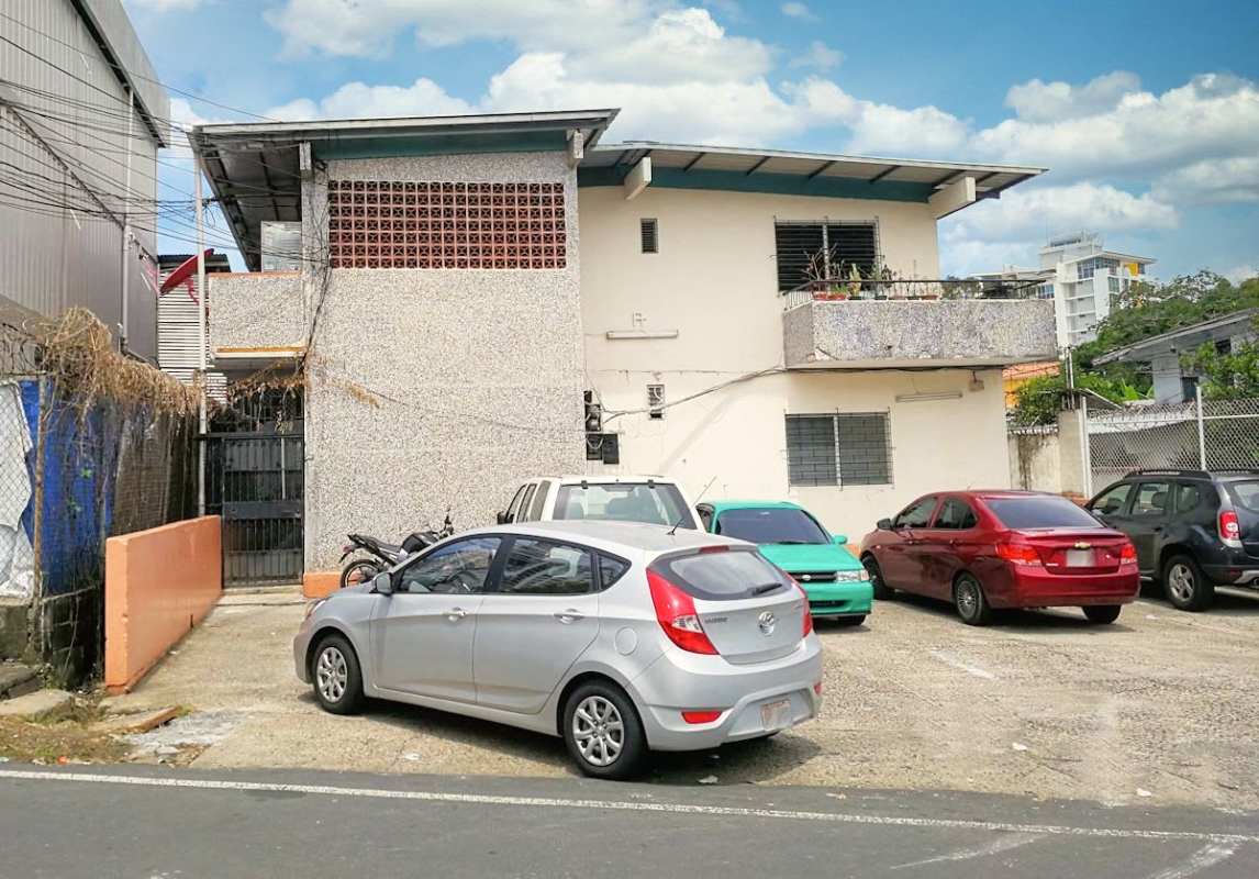 Multi-unit apartment building with balconies and gated parking area near Parque Omar Panama City
