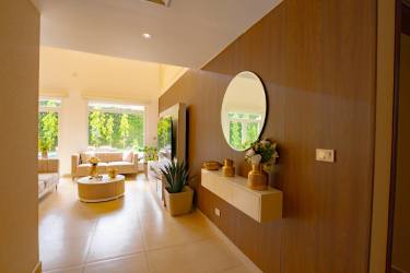 Bright luxury living room with wood accents, large windows at Tucan Country Club villa Panama