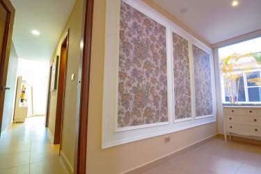 Stylish hallway with floral wallpaper and natural light in Tucan Country Club villa Panama