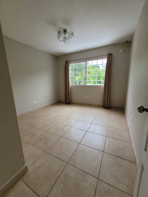 Living room with large sectional sofa, chandelier, tile floors, AC unit in furnished duplex Brisas del Golf Panama