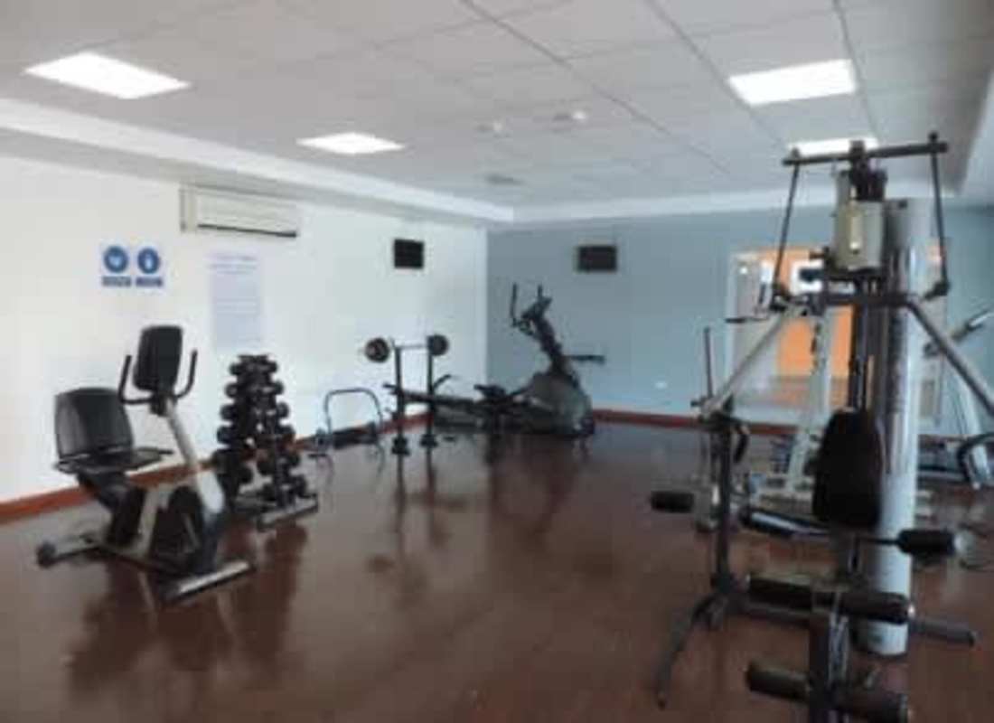 Fitness center with exercise equipment, weight racks, cardio machines in Brisas del Golf community Panama