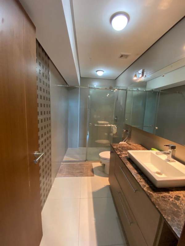 Modern ensuite bathroom with marble countertop and glass shower in Parkside Costa del Este apartment