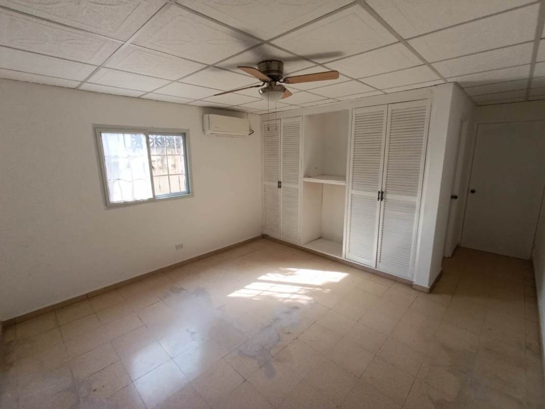 Minimalist bedroom with window, security bars, built-in closet and ceiling fan for rent Panama City