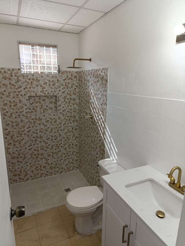 Contemporary bathroom with walk-in shower, marble sink and gold fixtures Campo Limberg Panama
