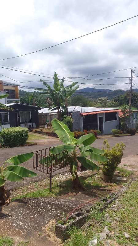Single-level peach house with porch light turquoise trim and small garden night Tocumen Panama