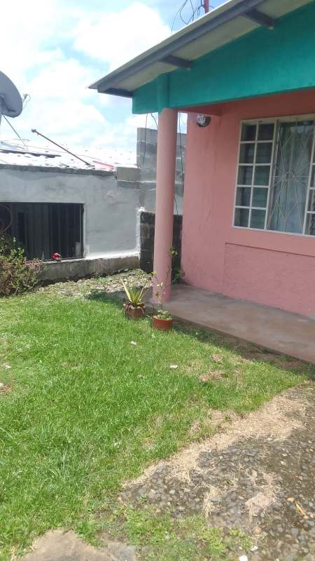 Pink facade with porch security door and garden in Residencial El Lago Tocumen Panama