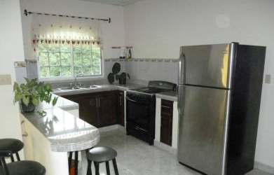 Spacious tiled living dining area with large windows, glass dining table, ceiling fan David Panama