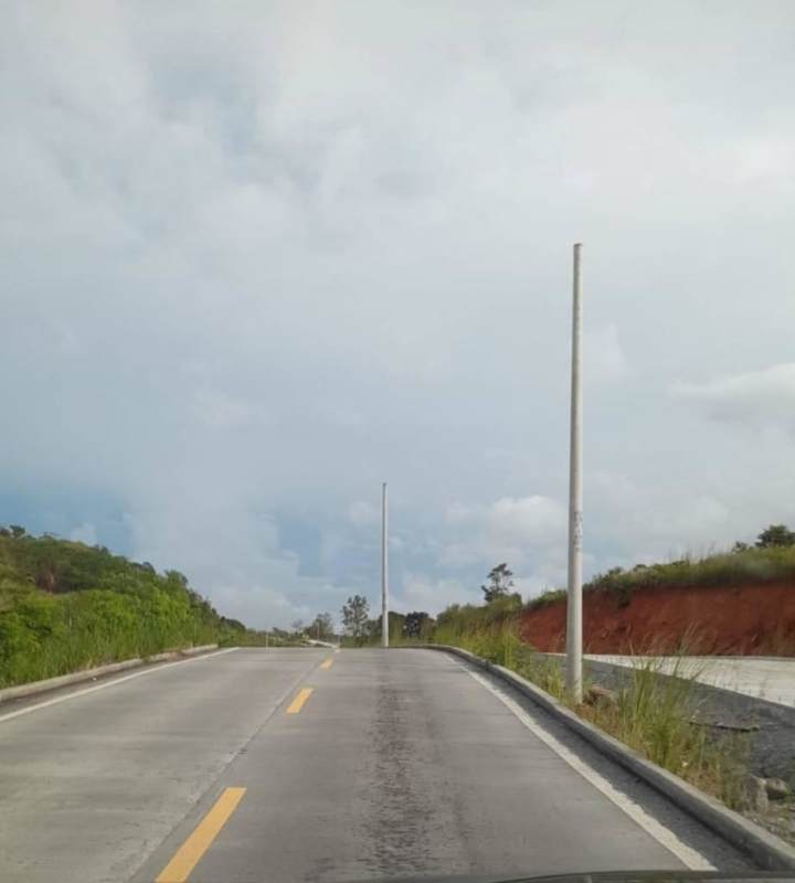 Fenced grassy open lot beside roadway in Villa Lobos Tocumen ideal for construction or investment Panama