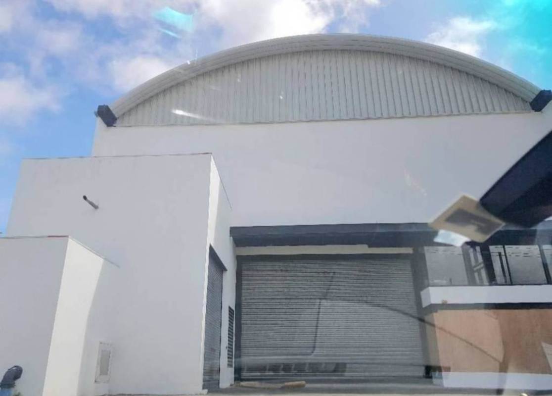 Modern industrial warehouse exterior with curved roof, loading dock Costa del Este Panama