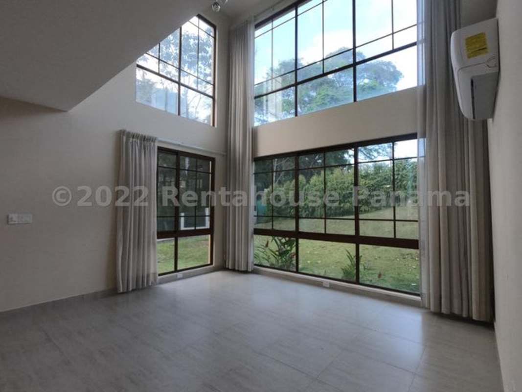 Double-height living room large windows garden view Senderos Camino de Cruces Panama City
