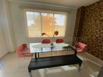 Open concept living dining area with balcony access in furnished Panama Pacifico apartment