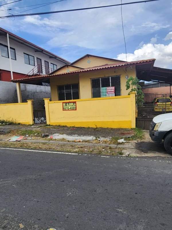 Single-story yellow commercial house with fenced yard and 'For Rent' signage Panama City